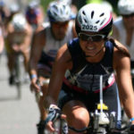 Woman wearing helmet and goggles riding a bicycle