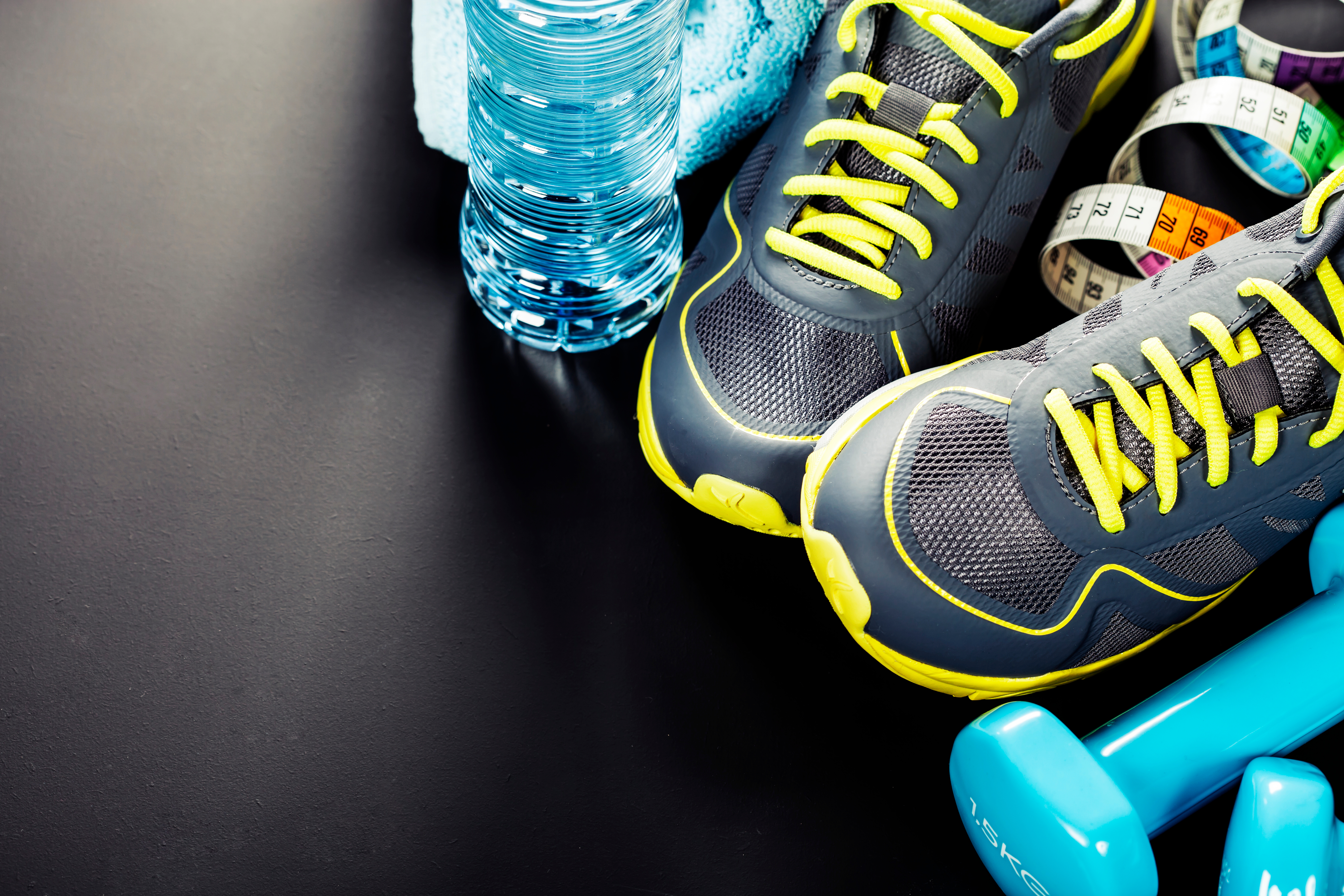 A pair of shoes and water bottle on the floor.