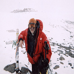 Man in snowy mountain with climbing gear.