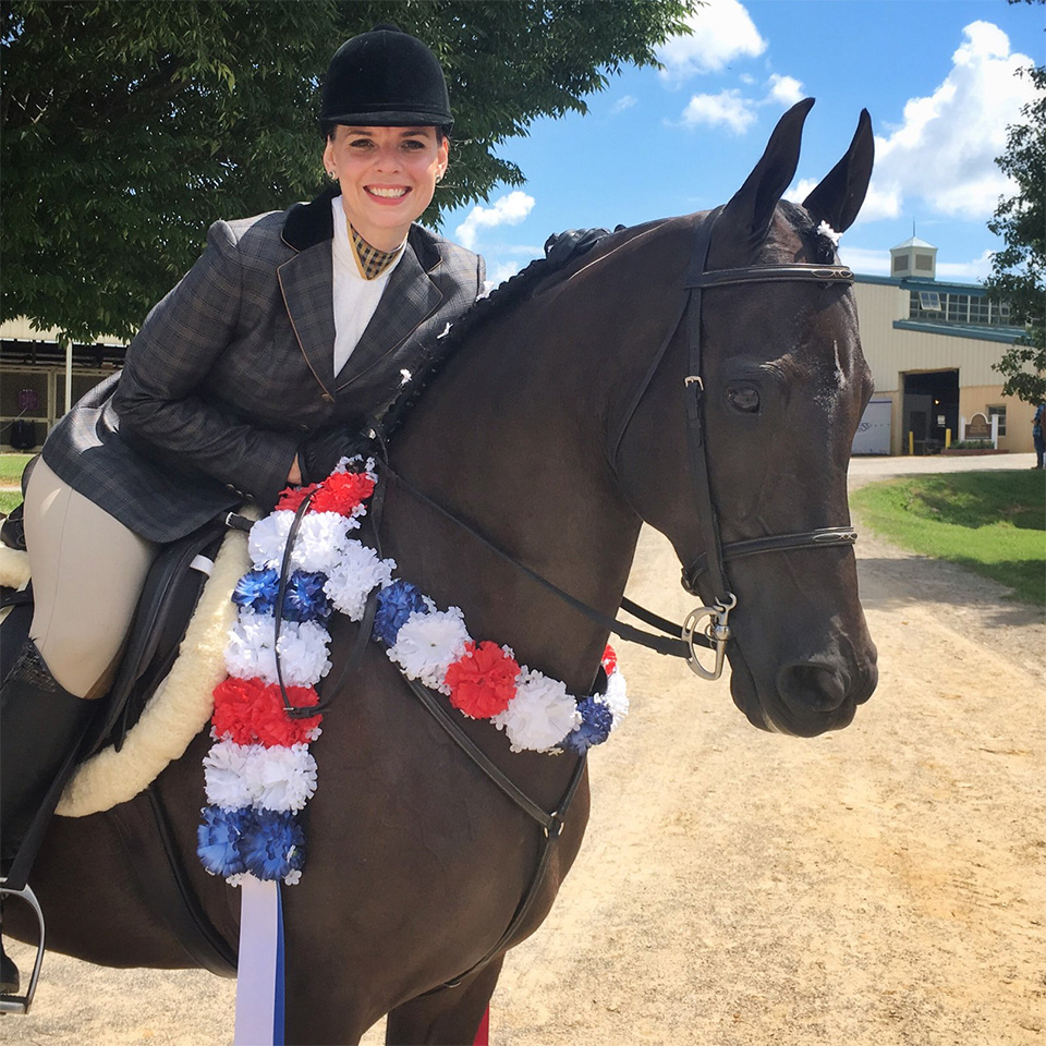 Equestrian rider with horse and floral garland.