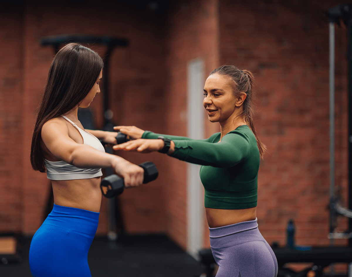 Women exercising with dumbbells in gym