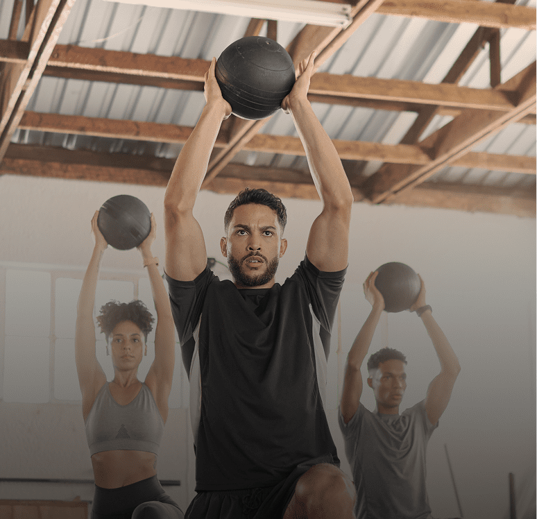 People exercising indoors with medicine balls